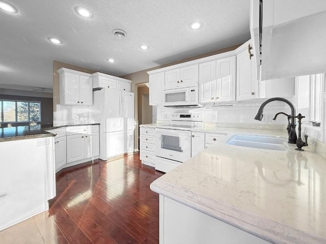 kitchen featuring sink, dark hardwood / wood-style floors, white appliances, decorative backsplash, and white cabinets