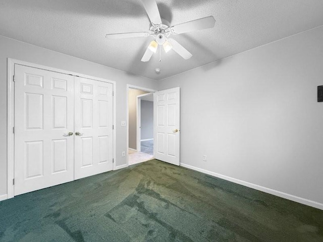 unfurnished bedroom with ceiling fan, a closet, dark carpet, and a textured ceiling