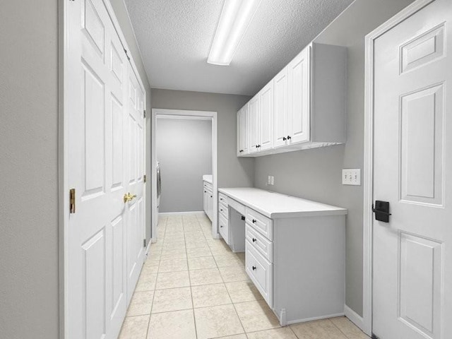 laundry room featuring light tile patterned flooring and a textured ceiling