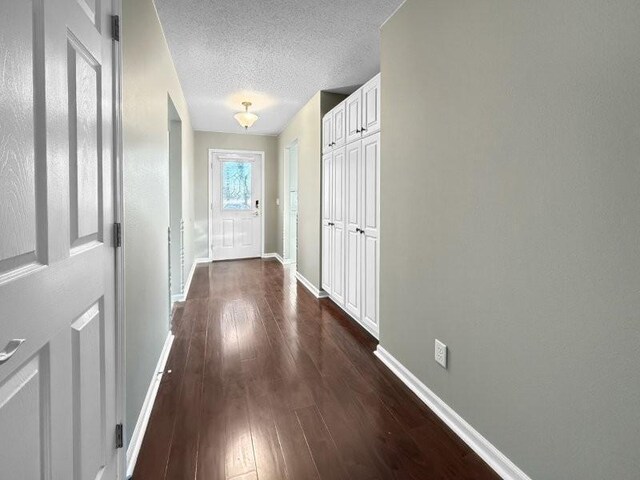 entryway with a textured ceiling and dark wood-type flooring