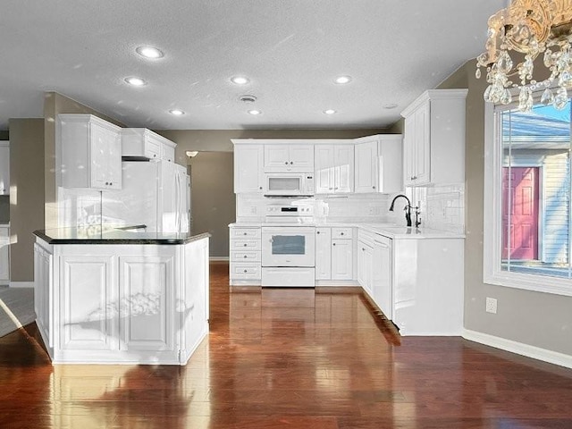 kitchen featuring decorative backsplash, white appliances, dark wood-type flooring, sink, and white cabinets