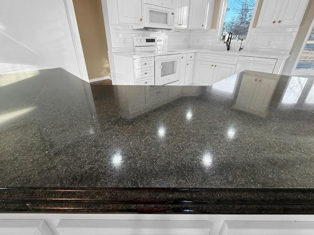 kitchen featuring decorative backsplash, white cabinetry, sink, and white appliances