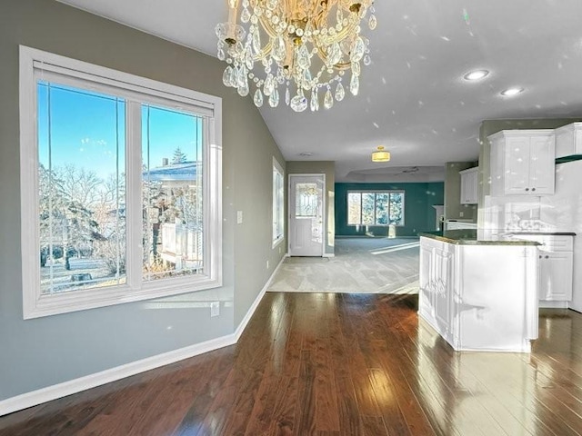 kitchen featuring white cabinets, decorative light fixtures, dark hardwood / wood-style flooring, and an inviting chandelier