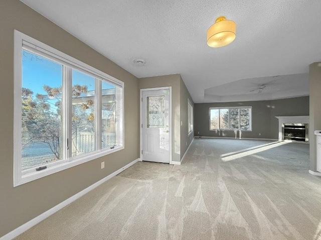 bonus room with ceiling fan, plenty of natural light, light colored carpet, and a textured ceiling