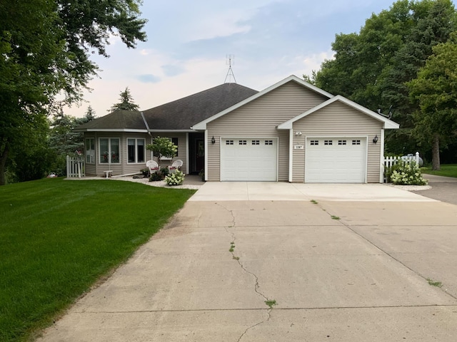 ranch-style house with a yard and a garage