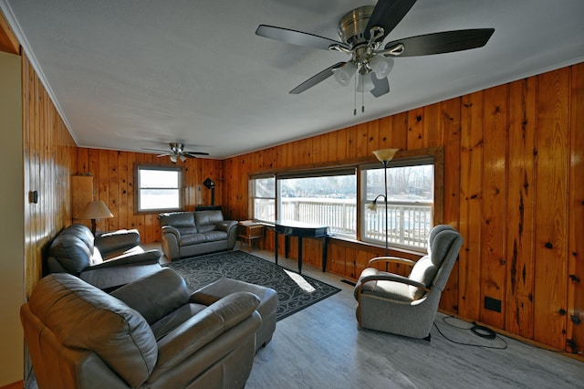 living room featuring wood walls, a healthy amount of sunlight, and light wood-type flooring