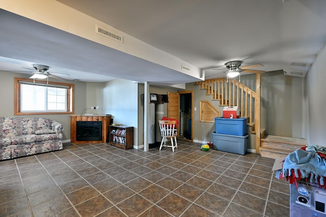 basement with ceiling fan and a fireplace