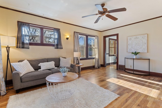 living room featuring ceiling fan, wood-type flooring, and crown molding