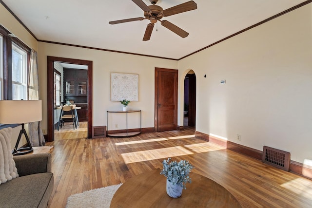 living room featuring ceiling fan, ornamental molding, and hardwood / wood-style flooring