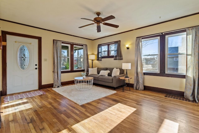 unfurnished living room featuring hardwood / wood-style floors, ceiling fan, and crown molding