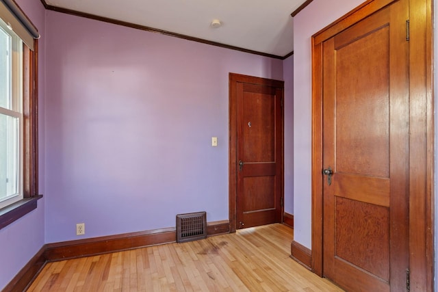 unfurnished bedroom with crown molding and light hardwood / wood-style floors