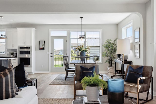 living room with a notable chandelier and light hardwood / wood-style floors