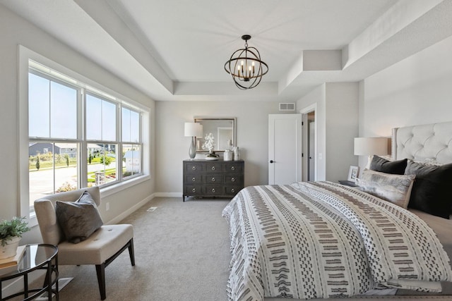 bedroom featuring a raised ceiling, light carpet, and a chandelier