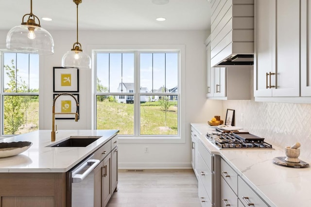 kitchen with light stone counters, sink, and white cabinets