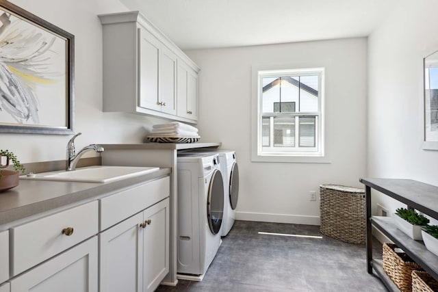 washroom with washer and dryer, sink, and cabinets