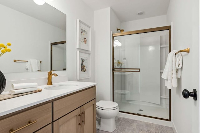 bathroom featuring toilet, vanity, and walk in shower