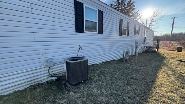 view of home's exterior with central AC unit and a lawn