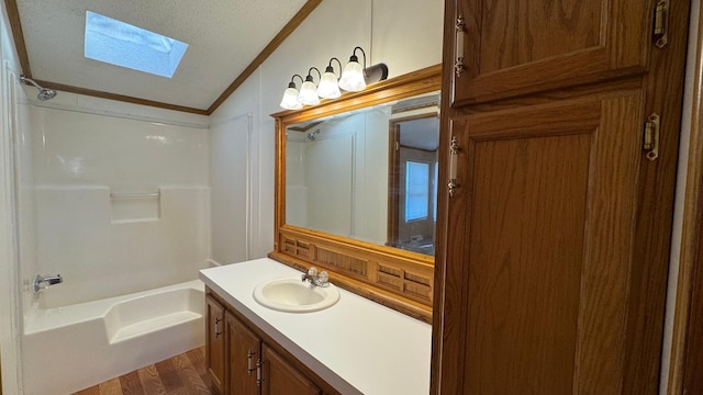 bathroom featuring vanity, bathing tub / shower combination, crown molding, vaulted ceiling with skylight, and wood-type flooring