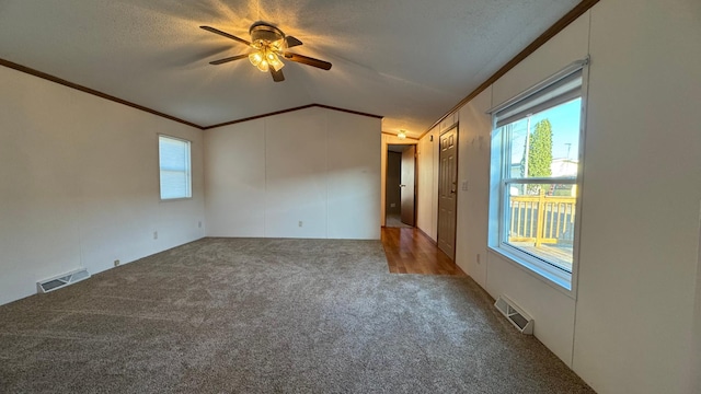 carpeted spare room with ceiling fan, ornamental molding, and a textured ceiling