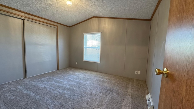 unfurnished bedroom featuring carpet flooring, a textured ceiling, crown molding, and lofted ceiling