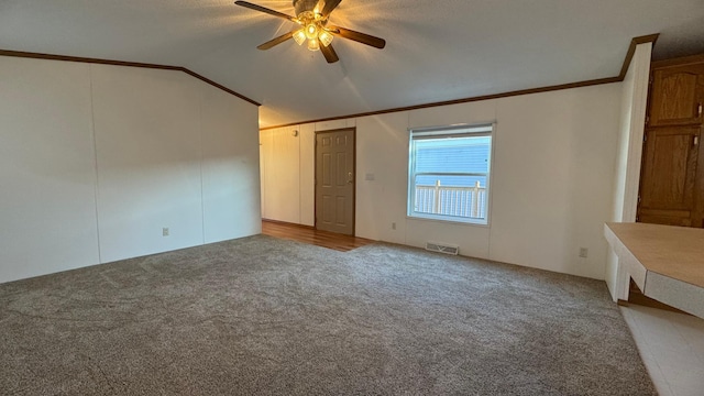 interior space featuring ceiling fan, light colored carpet, ornamental molding, and lofted ceiling