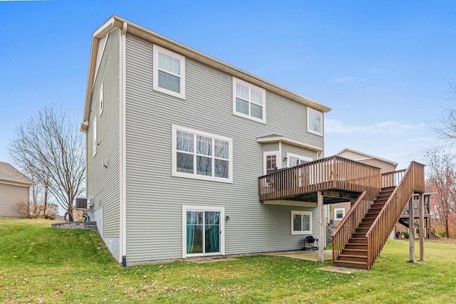 rear view of property with a wooden deck, a patio area, and a yard