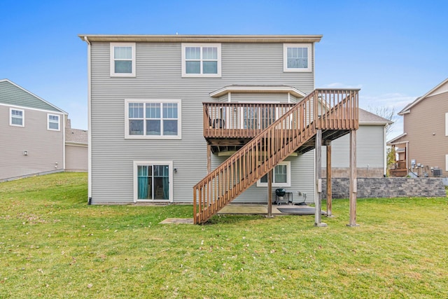 back of property featuring a deck, a patio area, and a lawn