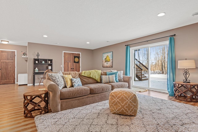 living room with a textured ceiling and light hardwood / wood-style flooring