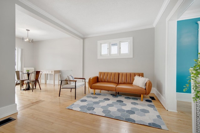 sitting room with light hardwood / wood-style floors and ornamental molding