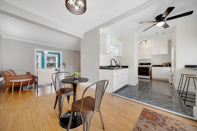 dining area featuring ceiling fan, light hardwood / wood-style floors, and sink