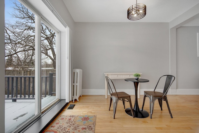 dining room with light hardwood / wood-style flooring and radiator