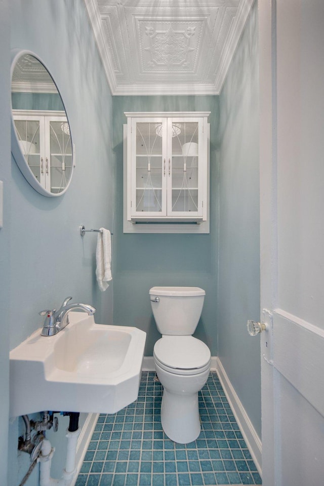 bathroom featuring sink, tile patterned flooring, crown molding, and toilet