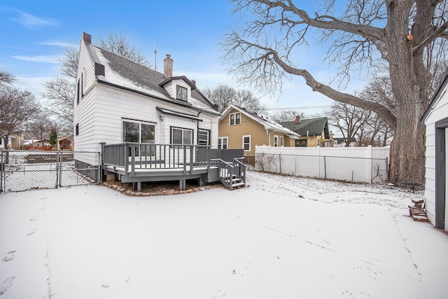 snow covered back of property featuring a wooden deck