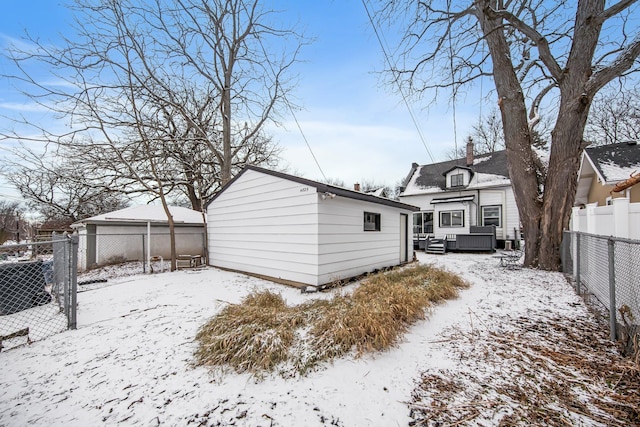 snow covered property featuring an outdoor structure