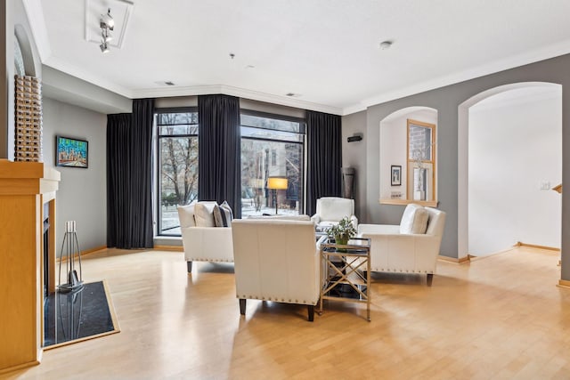 living room featuring crown molding and light hardwood / wood-style flooring