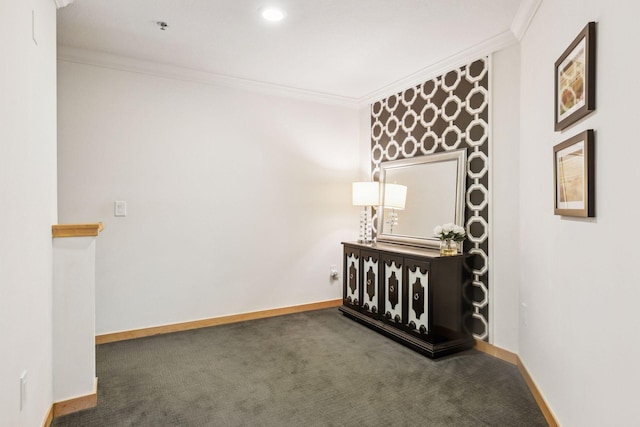 spare room featuring ornamental molding and dark colored carpet