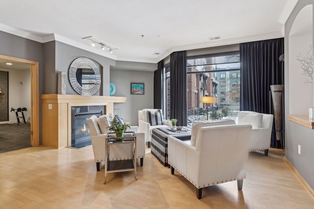 187 Sherman St, Saint Paul, MN 55102 - living area featuring light wood-style flooring, crown molding, a glass covered fireplace, rail lighting, and baseboards