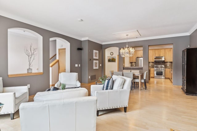 187 Sherman St, Saint Paul, MN 55102 - living room featuring arched walkways, a chandelier, light wood-type flooring, and crown molding