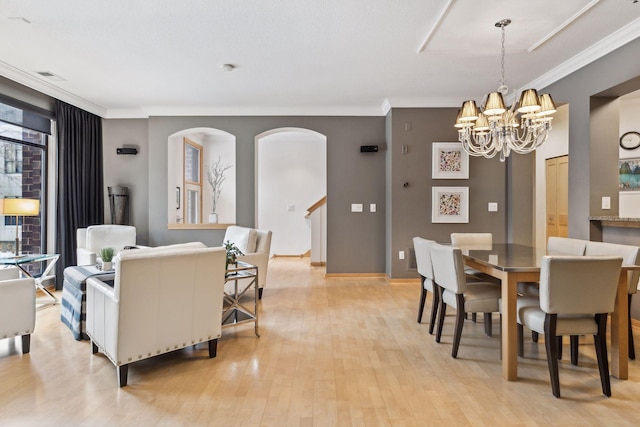 187 Sherman St, Saint Paul, MN 55102 - dining area featuring ornamental molding, a chandelier, arched walkways, light wood finished floors, and stairway