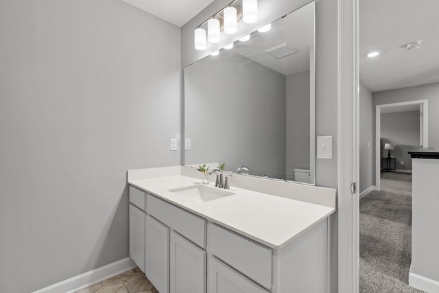 bathroom featuring vanity, a textured ceiling, and toilet