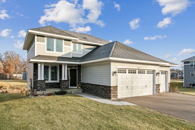 view of front of house with a porch, a garage, and a front lawn