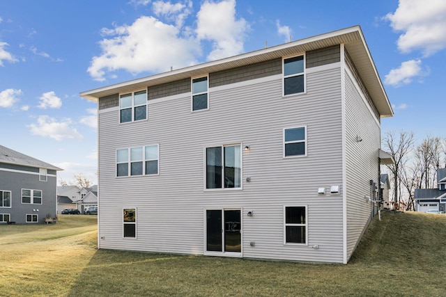 rear view of property featuring a lawn