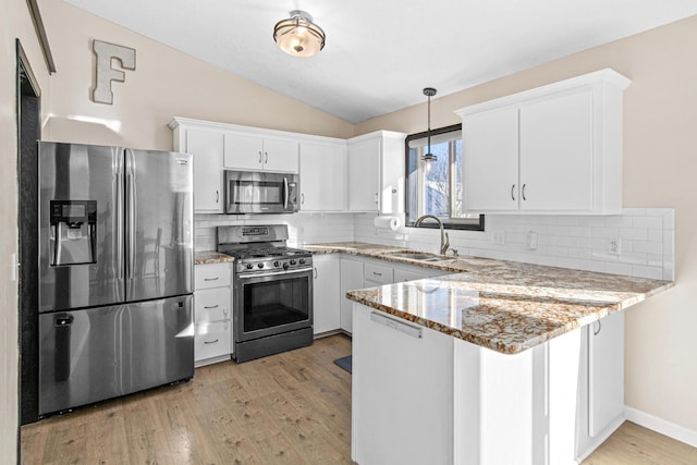 kitchen with appliances with stainless steel finishes, white cabinetry, and sink