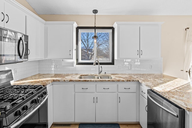 kitchen featuring white cabinets, appliances with stainless steel finishes, and sink