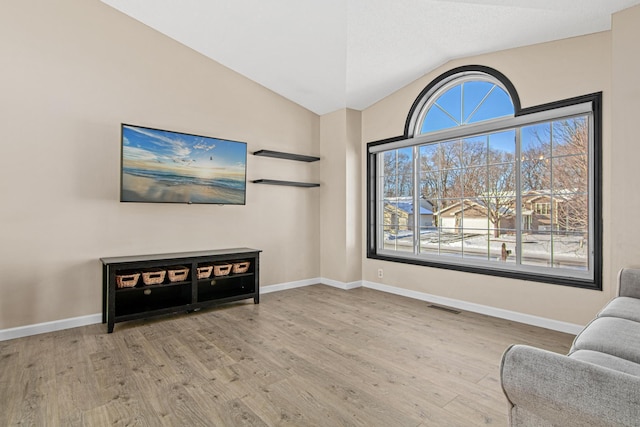 living area featuring light hardwood / wood-style floors and vaulted ceiling