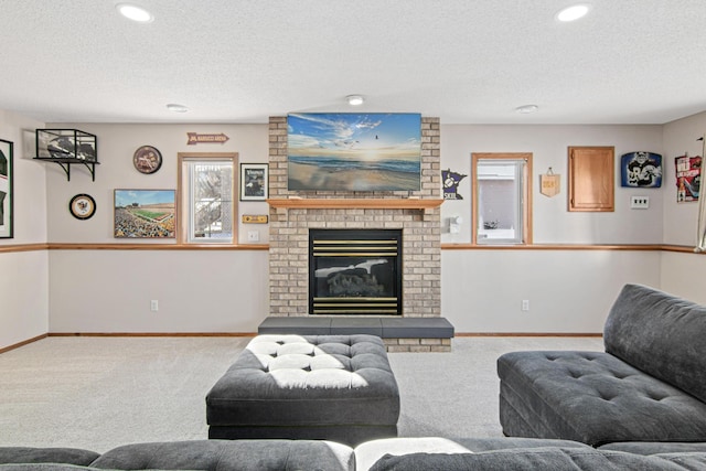 living room featuring a fireplace, a wealth of natural light, a textured ceiling, and carpet floors