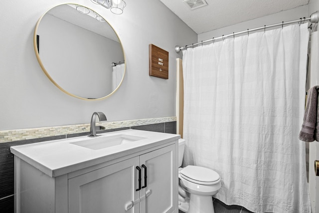 bathroom featuring a textured ceiling, vanity, and toilet