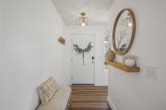 entryway featuring dark hardwood / wood-style flooring, a textured ceiling, and an inviting chandelier