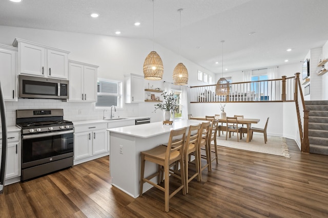 kitchen featuring appliances with stainless steel finishes, white cabinetry, pendant lighting, and sink