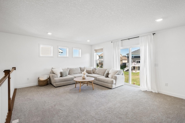 carpeted living room featuring a textured ceiling